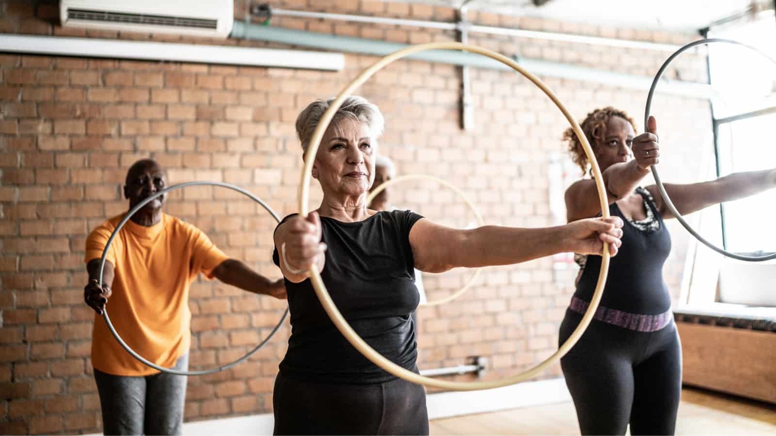 September 6th blog healthy senior citizens exercising in class with hula hoop