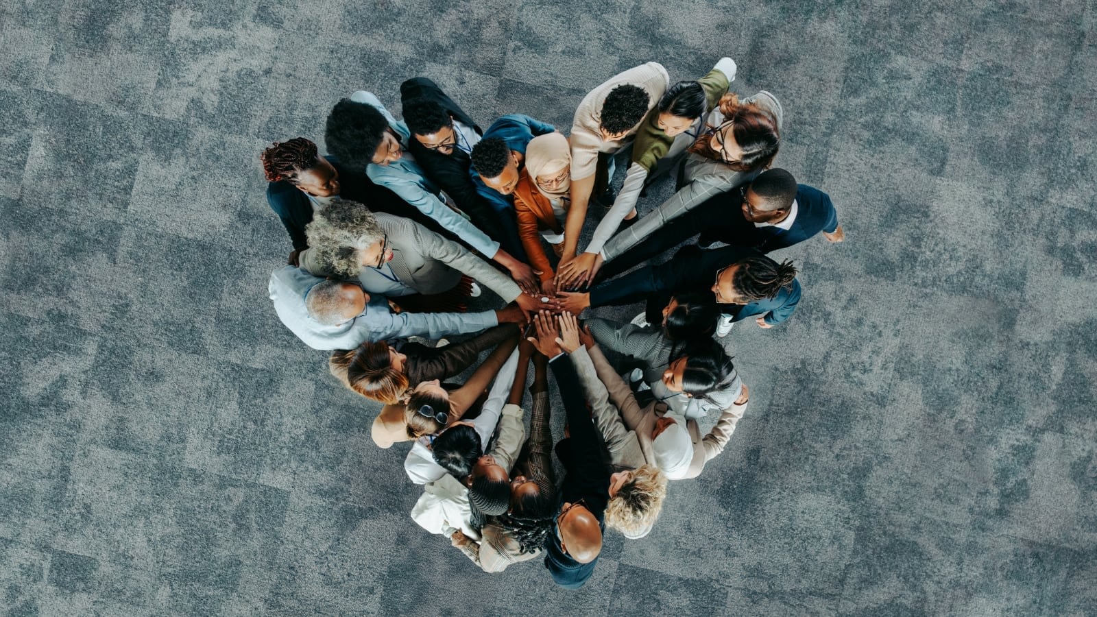 diverse staff uniting hands in a group huddle