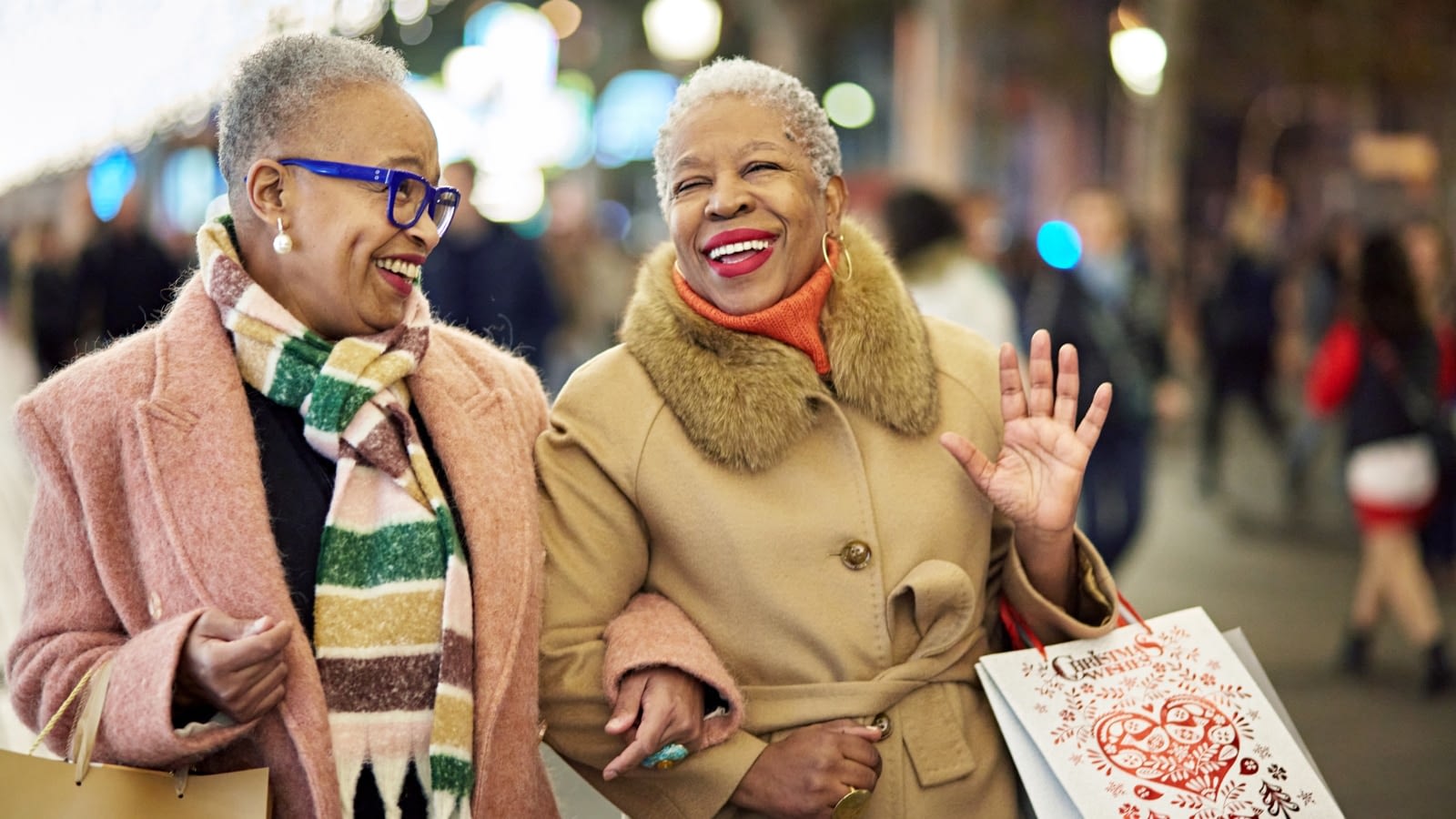 two older women cheerfully holiday shopping and strolling