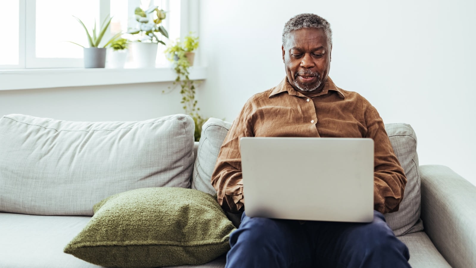 Senior citizen man reading on his laptop.