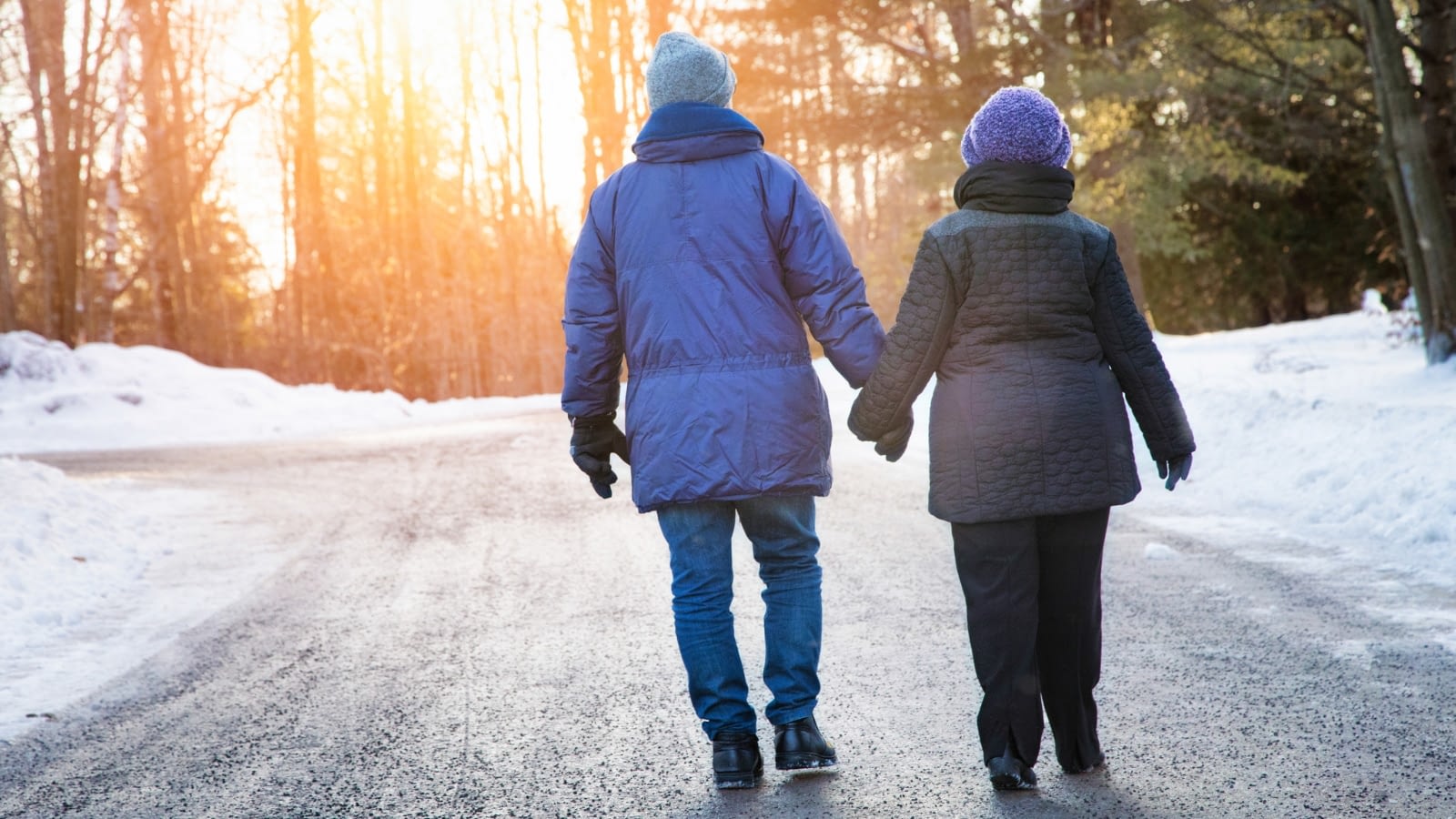 elderly couple going on a walk in the snow
