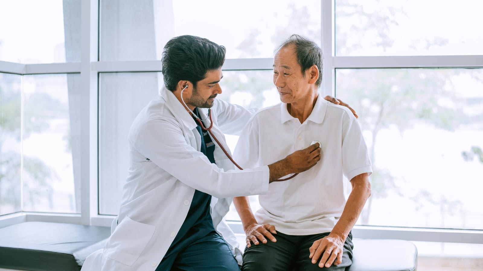 Male senior citizen having his heart checked on by doctor.