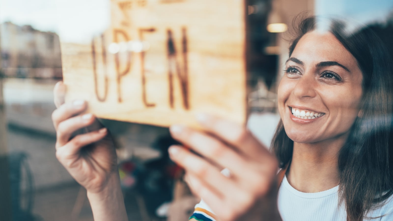 businesswoman turning window sign to open