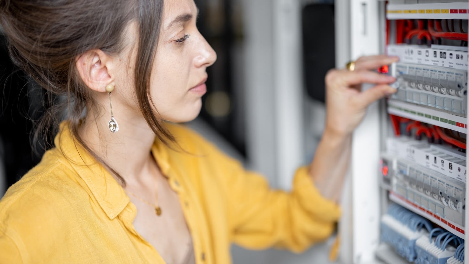 young woman inspecting electrical system in her home