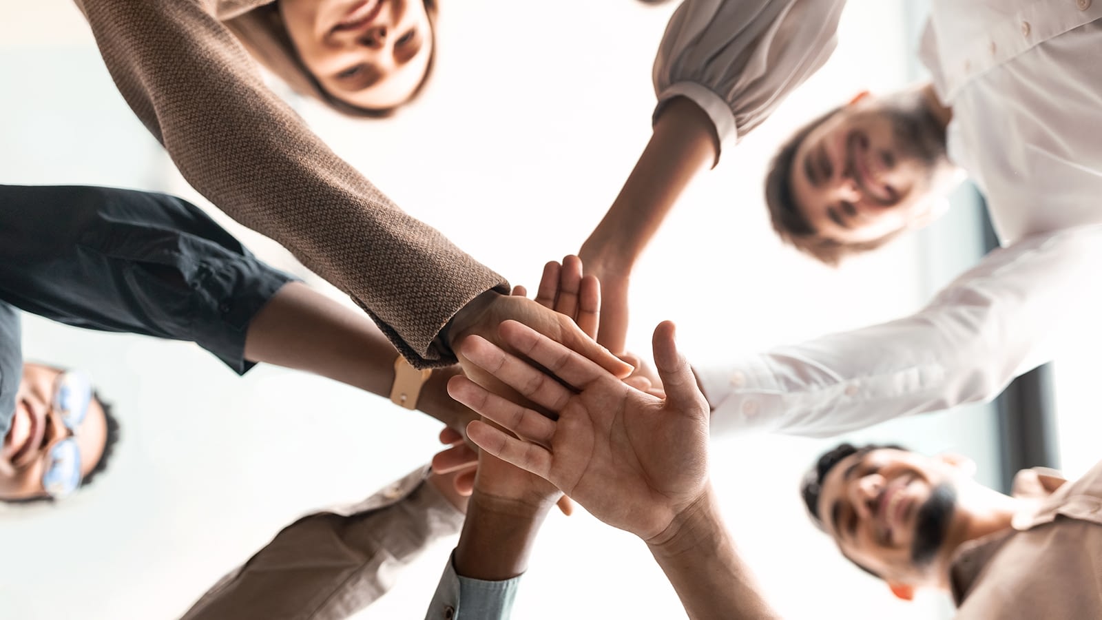 Group placing hands in middle of circle