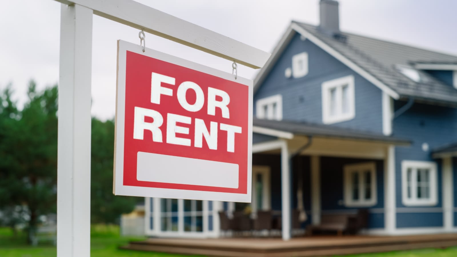 Home insurance for rental properties blue house with for rent sign in the front yard