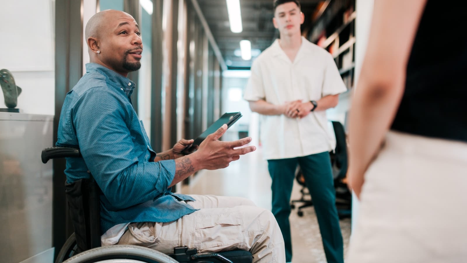 June 28 blog Man in wheelchair having a conversation with his coworkers.