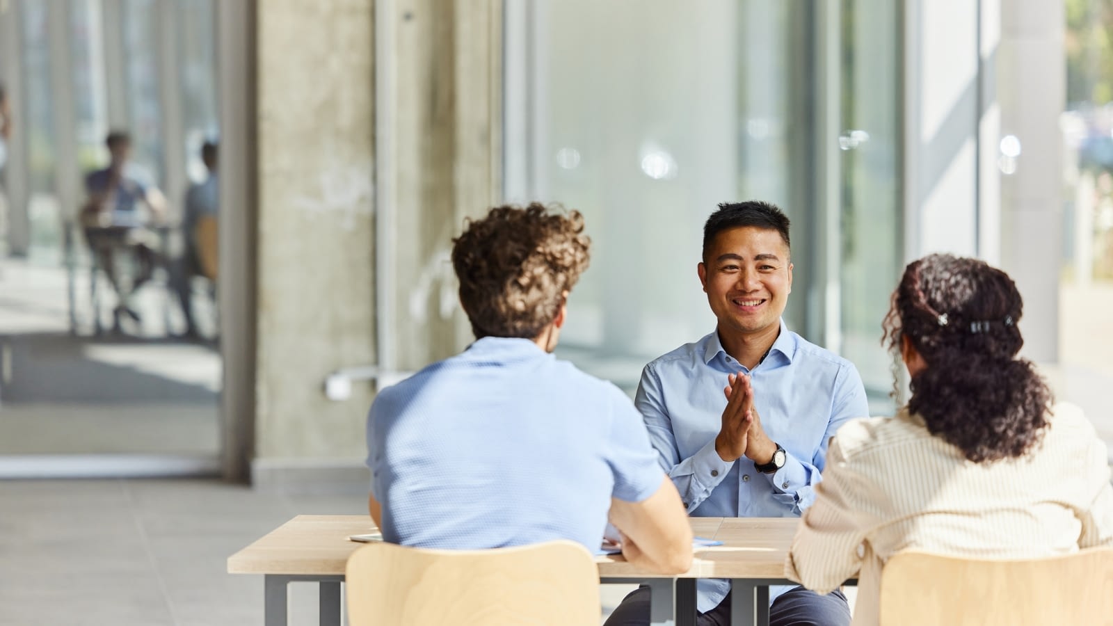 friendly male asian insurance agent discussing insurance with young couple