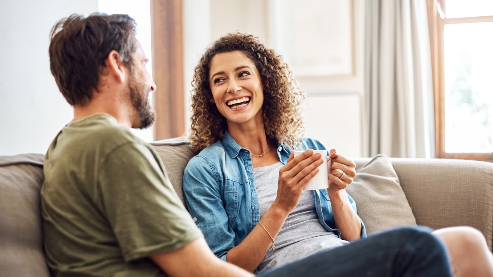 couple talking and smiling on their couch