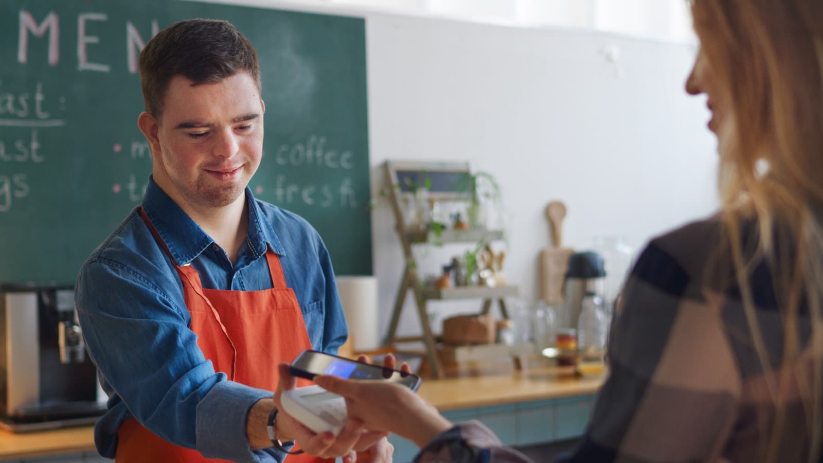 Mentally handicapped man working register at cafe
