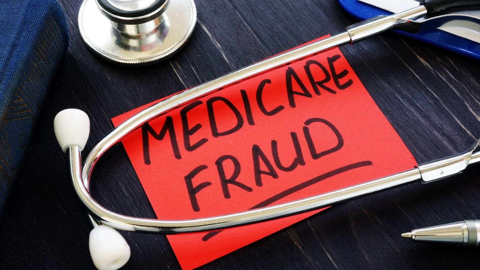 medicare scams stethescope on a table with medicare fraud written on a red note underneath it