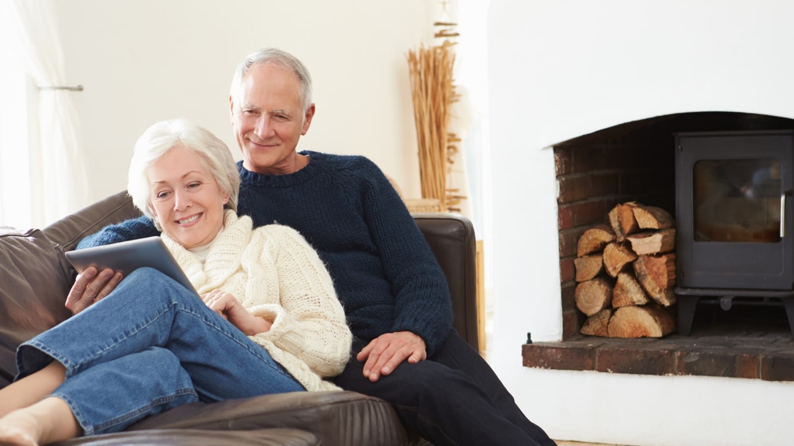 senior couple on couch researching on iPad