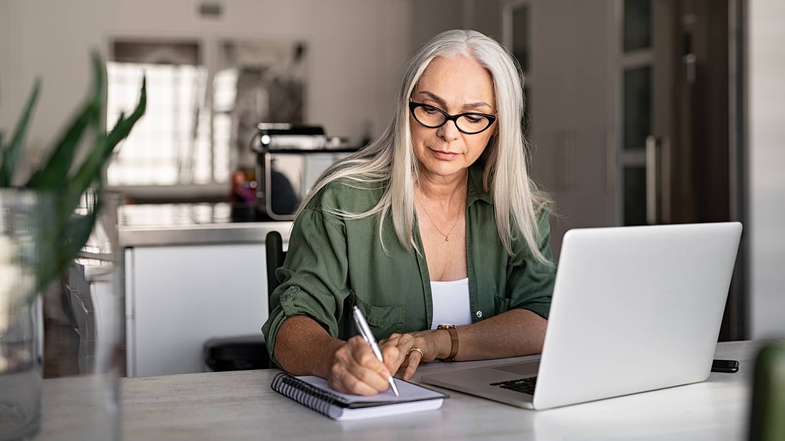 Woman writing while at computer