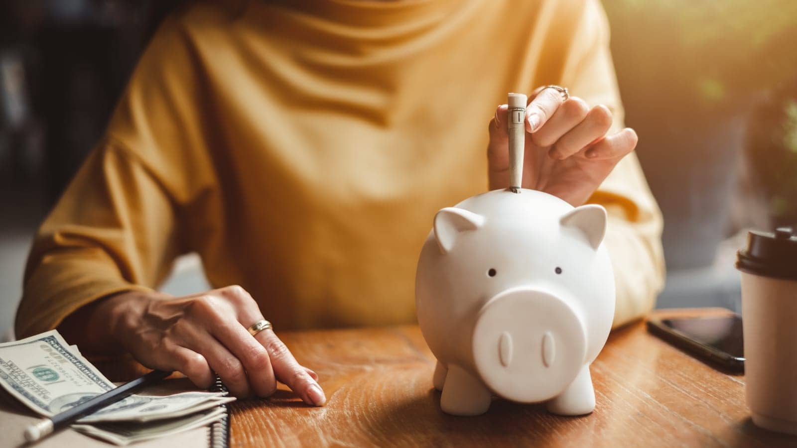 Woman adding money to a piggy bank