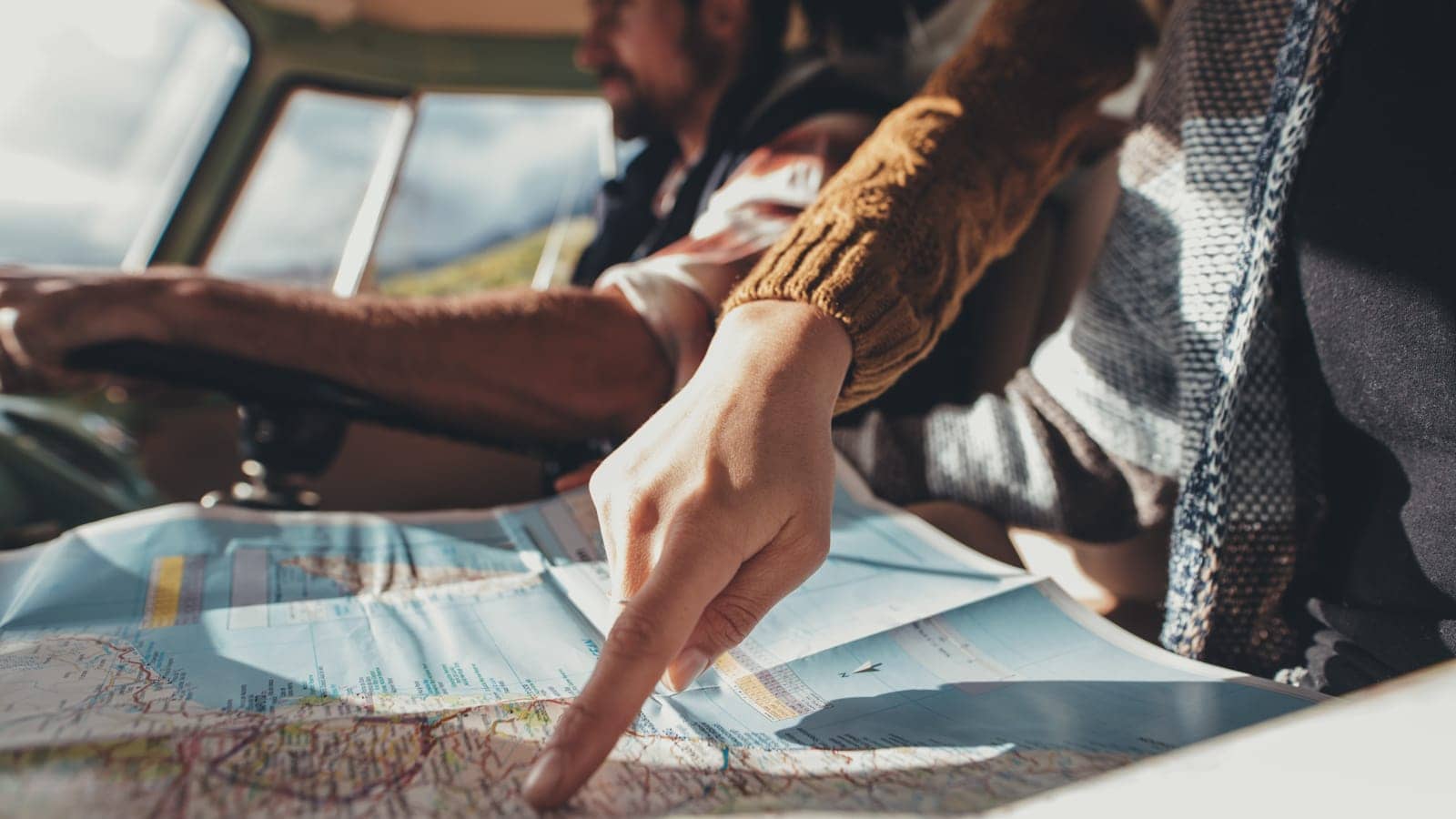 People using a map to navigate on a road trip