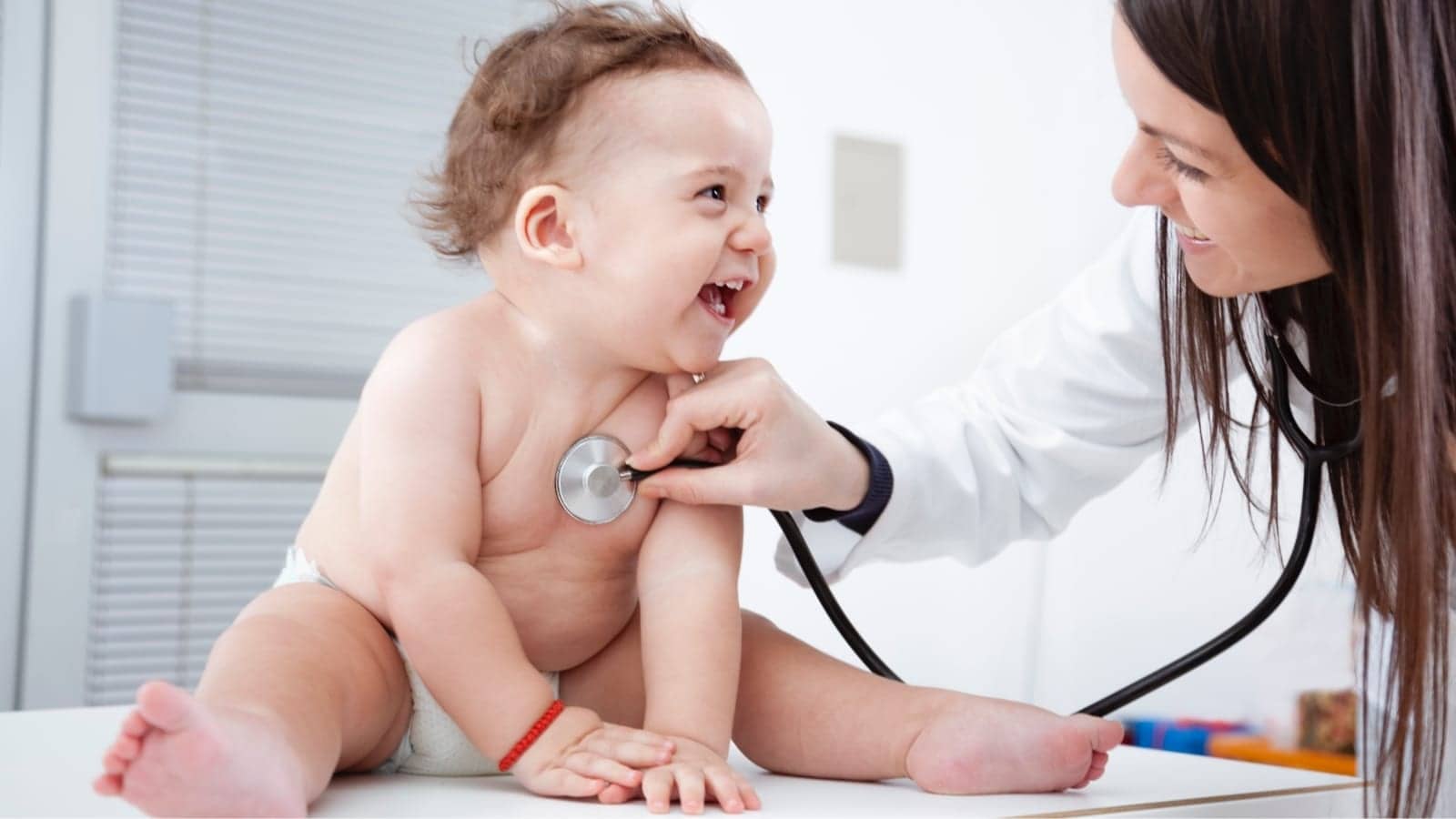 doctor with stethoscope checking babies heartbeat