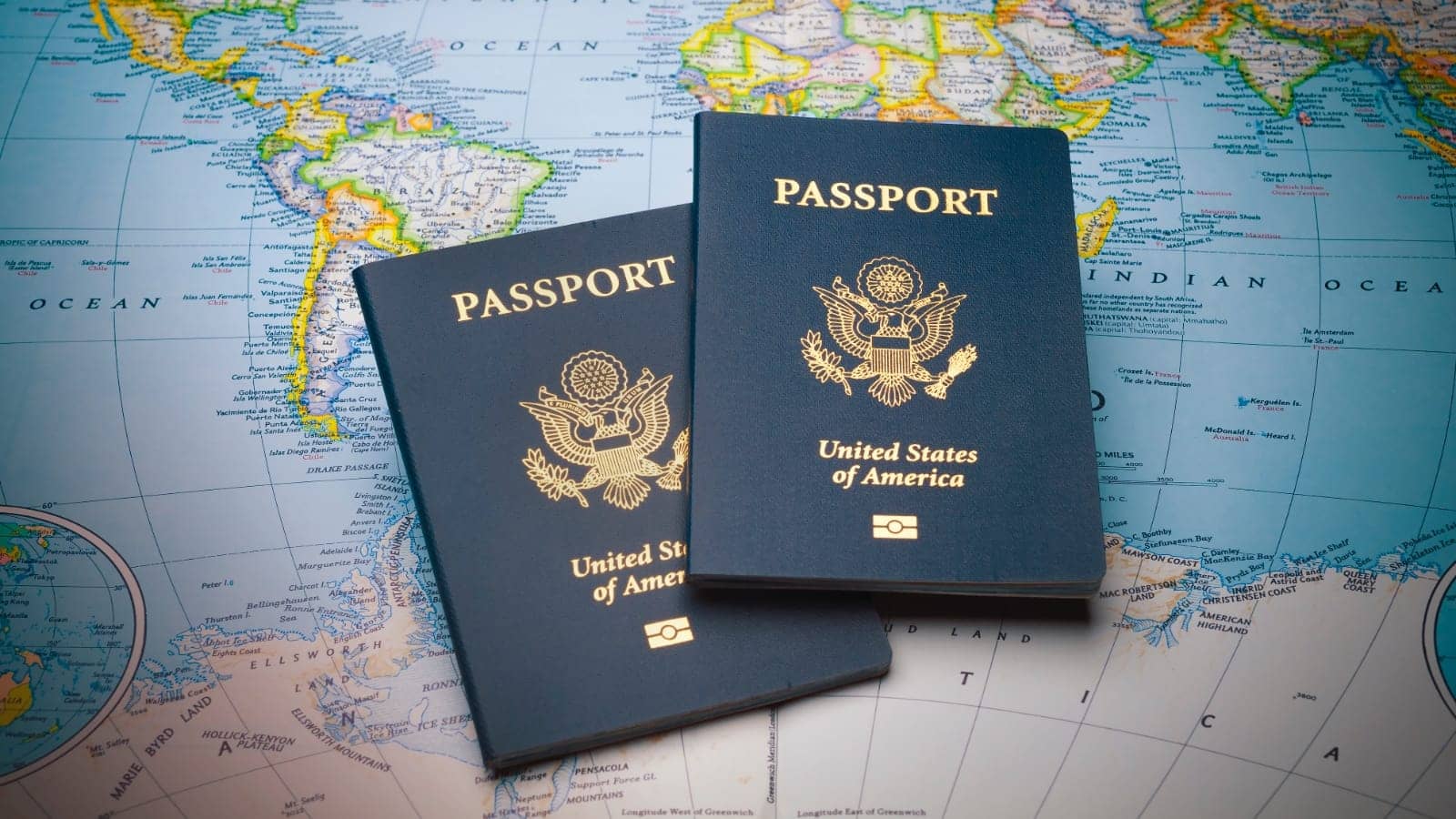two passports sitting on a colored map of the world