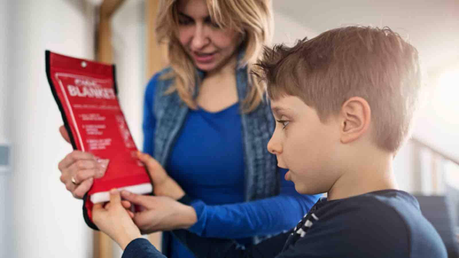 Mother and son studying a fire blanket