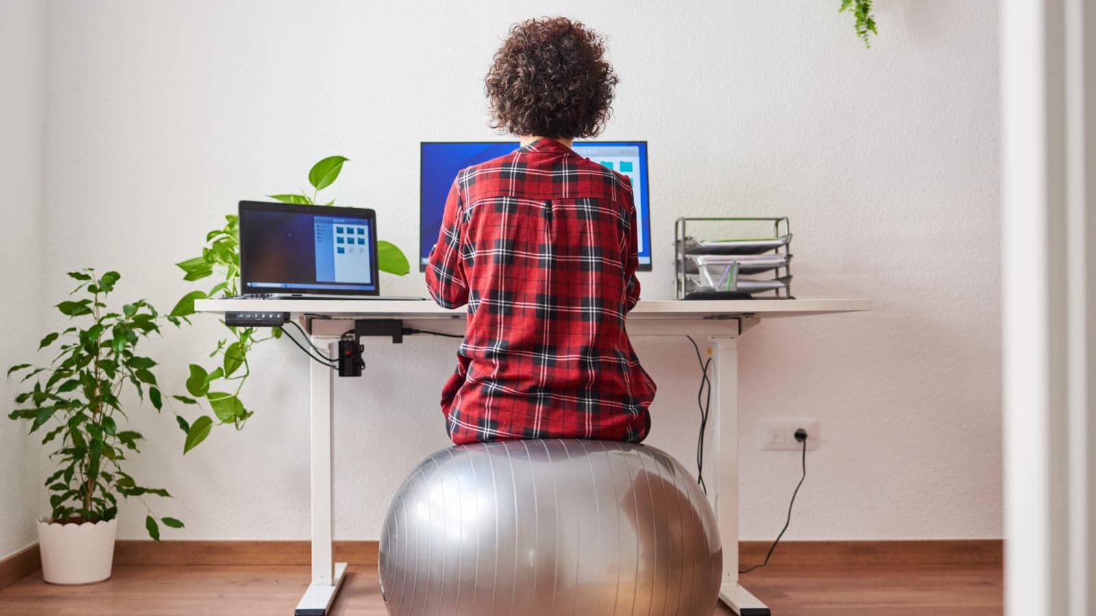 Woman working remote on exercise bal
