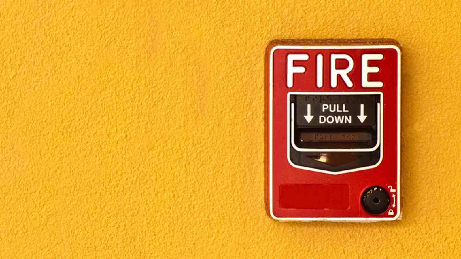 Fire alarm on a yellow wall