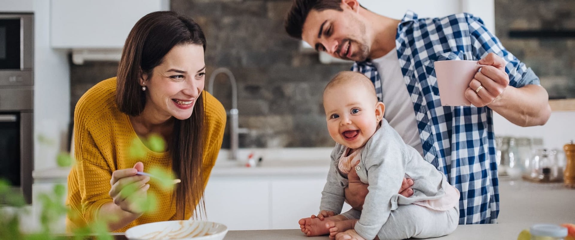 Happy Couple With Baby on Kitchen Counter