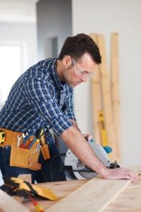 Male Contractor laying flooring down