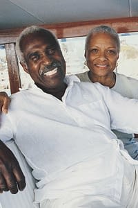 Retired couple sitting at the helm of a luxury yacht.