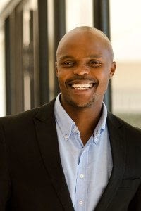 Businessman Smiles as he Stands in Front of his Office Building