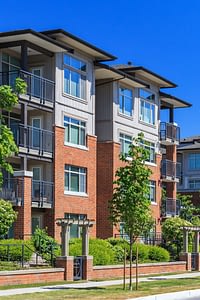 Brick condominium building with trees in front