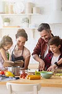 Family of four cooking together in kitchen
