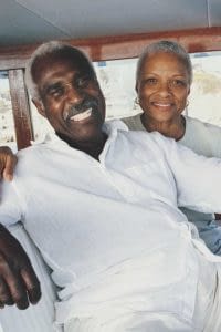 Retired couple sitting at the helm of a luxury yacht.