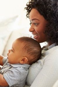 Woman Smiles Holding Her Baby in Her Lap