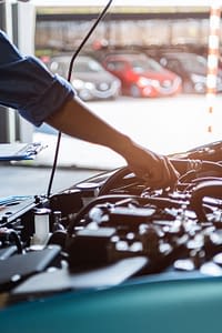 Mechanic working under the hood of an automobile.