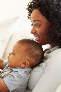 Woman Smiles as She Holds her Baby in Her Lap