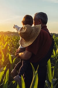 Father and son standing in a field at their farm