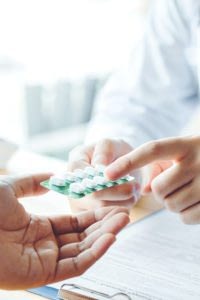 Close-up of pharmacist explaining medication to a patient.