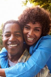 Close up of retired couple smiling at the camera.