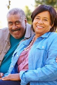 Middle-Aged Man and Woman Sit and Smile at the Camera