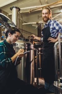 Man and women brewing beer at a brewery.