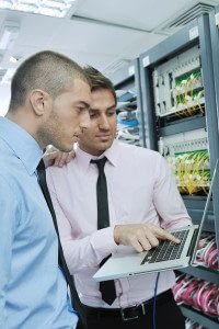 Two Male Businessmen Examining Technology Features on a Laptop