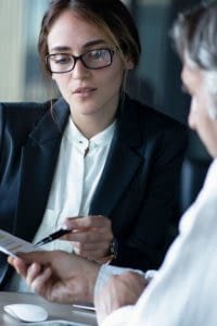 Business woman in a meeting with a man looking at a piece of paper