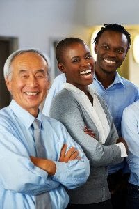 Three Adult Employees Stand and Smile at the Camera