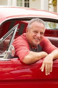 Man Leans Out of the Front Window of His Classic Car