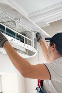 Technician repairing air conditioner at home