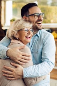 Happy senior mother and son embrace.