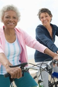 Two Senior Women Riding Bicycles on the Beach