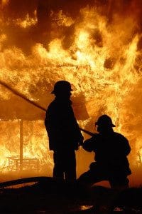 Silhouette of Two Firefighters at the Scene of a Commercial Business Property On Fire
