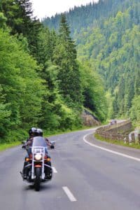 Person riding a motorcycle along a mountain road