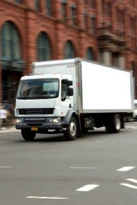 White Commercial Truck Driving Down the Road