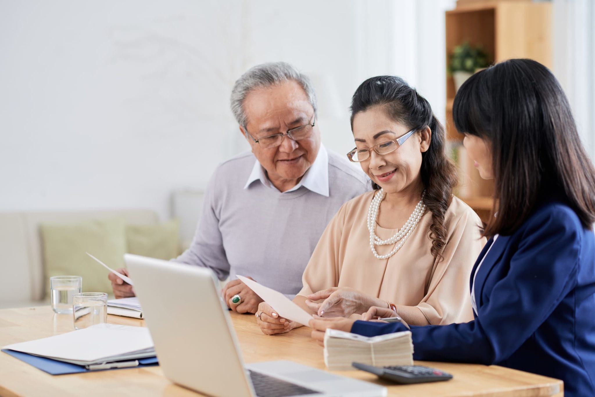 Happy Asian Couple Speaking With Advisor